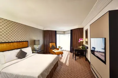 a hotel room with a bed and a desk at Grand Millennium Kuala Lumpur in Kuala Lumpur