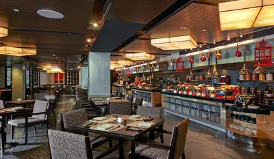 a restaurant with tables and chairs and a bar at Grand Millennium Kuala Lumpur in Kuala Lumpur