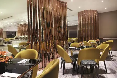 a restaurant with tables and chairs in a room at Dorsett Kuala Lumpur in Kuala Lumpur