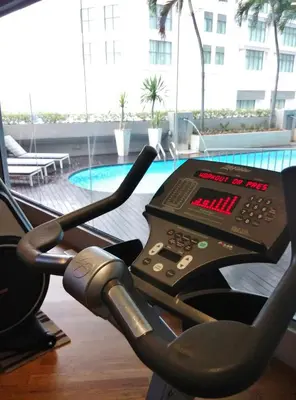 a gym with an exercise machine in front of a pool at Dorsett Kuala Lumpur in Kuala Lumpur