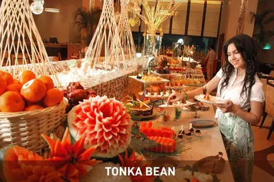 a woman standing in front of a buffet of food at Impiana KLCC Hotel in Kuala Lumpur