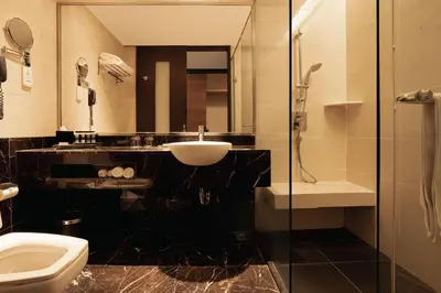a bathroom with a sink and a toilet and a shower at Impiana KLCC Hotel in Kuala Lumpur