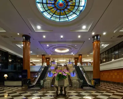 a lobby with a stained glass window and escalators at Seri Pacific Hotel Kuala Lumpur in Kuala Lumpur