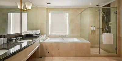 a bathroom with a tub and a shower and a sink at InterContinental Kuala Lumpur by IHG in Kuala Lumpur