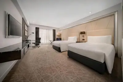 a hotel room with two beds and a television at InterContinental Kuala Lumpur by IHG in Kuala Lumpur