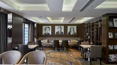a library with tables and chairs and bookshelves at InterContinental Kuala Lumpur by IHG in Kuala Lumpur