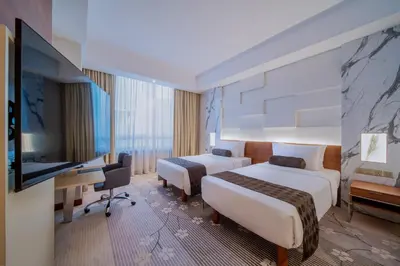 a hotel room with two beds and a desk at St Giles Boulevard in Kuala Lumpur