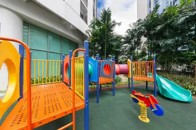 a playground with a slide in front of a building at Ascott Kuala Lumpur in Kuala Lumpur