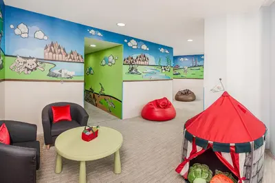 a childrens room with a red tent and chairs at Ascott Kuala Lumpur in Kuala Lumpur