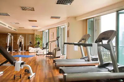 a gym with several treadmills and elliptical machines at Ascott Kuala Lumpur in Kuala Lumpur