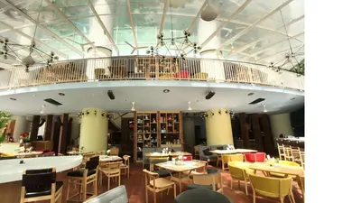 a restaurant with tables and chairs and a balcony at Ascott Kuala Lumpur in Kuala Lumpur