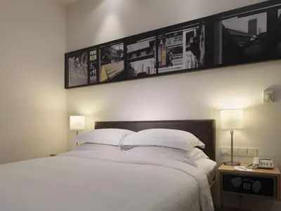 a bedroom with a large bed with white sheets and pillows at Hotel Capitol Kuala Lumpur in Kuala Lumpur
