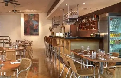 a restaurant with tables and chairs and a bar at Hotel Capitol Kuala Lumpur in Kuala Lumpur