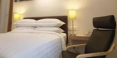 a hotel room with a bed and a chair at Hotel Capitol Kuala Lumpur in Kuala Lumpur
