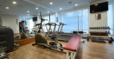 a gym with exercise bikes and a treadmill at Hotel Royal Kuala Lumpur in Kuala Lumpur