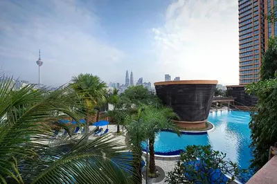 a view of a pool with palm trees and a city at Berjaya Times Square Hotel, Kuala Lumpur in Kuala Lumpur