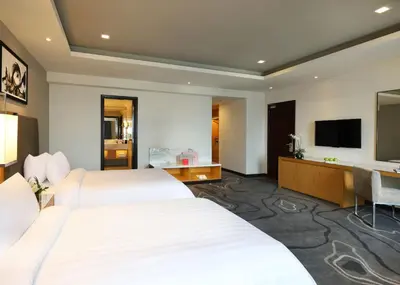 a hotel room with two beds and a desk at Berjaya Times Square Hotel, Kuala Lumpur in Kuala Lumpur