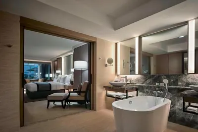 a bathroom with a tub and a bedroom with a bed at JW Marriott Kuala Lumpur in Kuala Lumpur