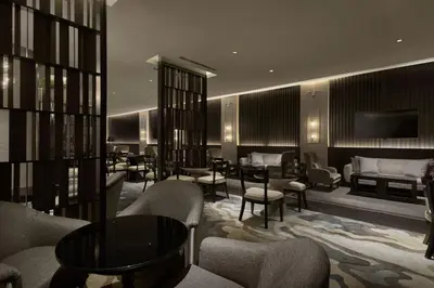 a hotel lobby with chairs and tables and a television at JW Marriott Kuala Lumpur in Kuala Lumpur