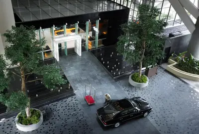 a black car parked in the middle of a building with trees at Hotel Maya Kuala Lumpur City Centre in Kuala Lumpur