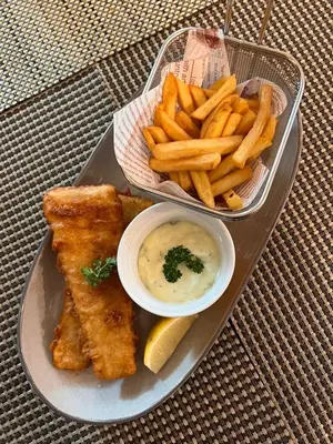 a tray of food with fish and french fries and dip at Hotel Maya Kuala Lumpur City Centre in Kuala Lumpur