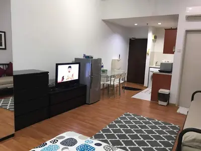 a living room with a television and a kitchen at MayTower Serviced Apartment in Kuala Lumpur