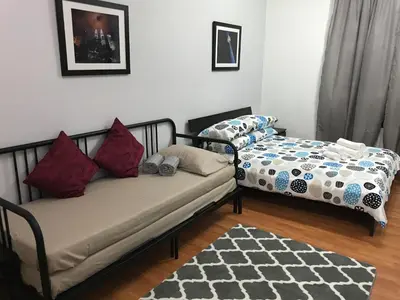 a living room with two beds and a rug at MayTower Serviced Apartment in Kuala Lumpur