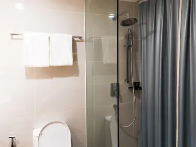 a bathroom with a shower with a toilet and a shower curtain at Starus Hotel Bukit Bintang in Kuala Lumpur