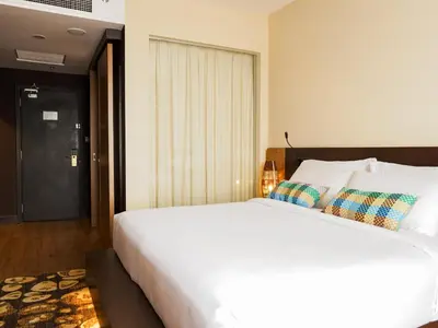 a bedroom with a large white bed and a door at Starus Hotel Bukit Bintang in Kuala Lumpur