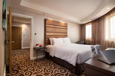 a hotel room with a bed and a laptop on a desk at Sunway Putra Hotel Kuala Lumpur in Kuala Lumpur