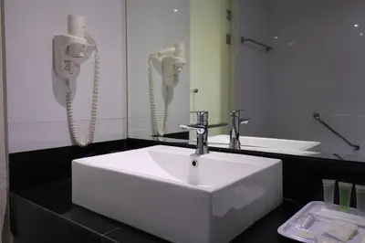 a bathroom with a white sink and a phone at Hotel Grand Continental Kuala Lumpur in Kuala Lumpur