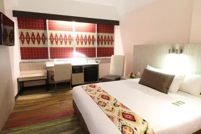 a hotel room with a bed and a desk at Hotel Grand Continental Kuala Lumpur in Kuala Lumpur