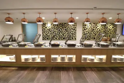a restaurant counter with plates on display at Hotel Grand Continental Kuala Lumpur in Kuala Lumpur