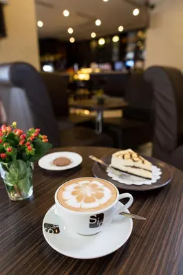 a cup of coffee and a piece of cake on a table at Prescott Hotel Kuala Lumpur Medan Tuanku in Kuala Lumpur
