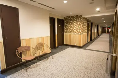a hallway with two chairs and a wall at Prescott Hotel Kuala Lumpur Medan Tuanku in Kuala Lumpur