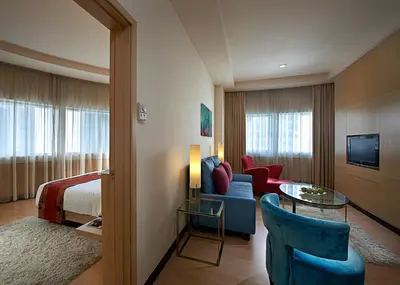 a hotel room with a bed and a living room at ANSA Hotel Kuala Lumpur in Kuala Lumpur