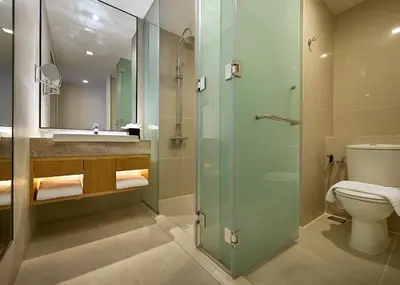 a bathroom with a toilet and a glass shower at ANSA Hotel Kuala Lumpur in Kuala Lumpur