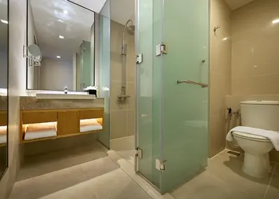 a bathroom with a toilet and a glass shower at ANSA Hotel Kuala Lumpur in Kuala Lumpur