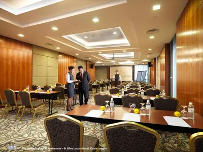 two men standing in a conference room with tables and chairs at St Giles Mid Valley Kuala Lumpur in Kuala Lumpur
