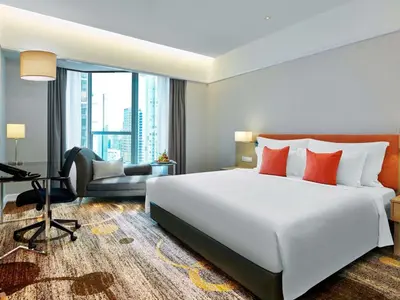 a bedroom with a large white bed and a desk at Pullman Kuala Lumpur City Centre Hotel & Residences in Kuala Lumpur