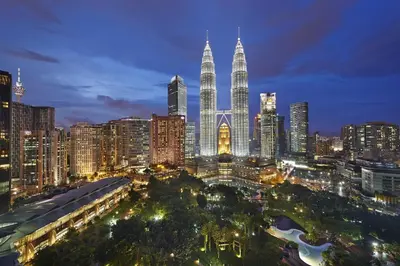 a city skyline at night with the petronas towers at Mandarin Oriental, Kuala Lumpur in Kuala Lumpur