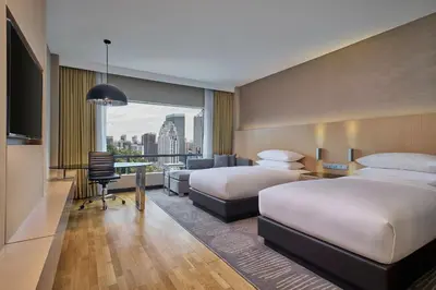 a hotel room with two beds and a desk at Renaissance Kuala Lumpur Hotel & Convention Centre in Kuala Lumpur
