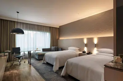 a hotel room with two beds and a desk at Renaissance Kuala Lumpur Hotel & Convention Centre in Kuala Lumpur