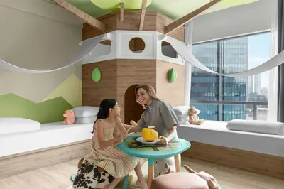 a woman and a girl in a room with a table at Renaissance Kuala Lumpur Hotel & Convention Centre in Kuala Lumpur