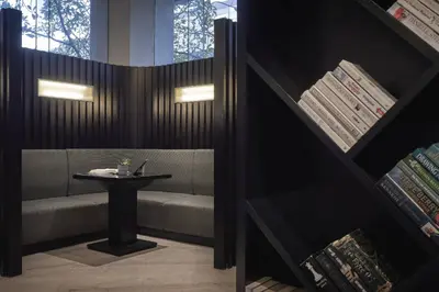 a table and a bench in a room with a table at AC Hotel by Marriott Kuala Lumpur in Kuala Lumpur