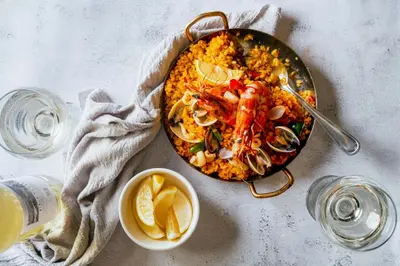 a table with a pan of food with shrimp and vegetables at AC Hotel by Marriott Kuala Lumpur in Kuala Lumpur