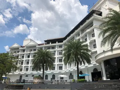 a large white building with palm trees in front of it at Flamingo Hotel By The Lake, Kuala Lumpur in Kuala Lumpur