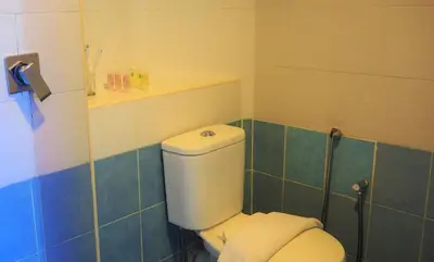 a bathroom with a white toilet and blue tiles at WTC Hotel, Kuala Lumpur - Formerly Leo Palace Hotel Classic Wing in Kuala Lumpur
