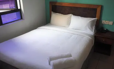 a large white bed in a room with a window at WTC Hotel, Kuala Lumpur - Formerly Leo Palace Hotel Classic Wing in Kuala Lumpur