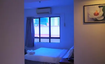 a blue room with a bed and a window at WTC Hotel, Kuala Lumpur - Formerly Leo Palace Hotel Classic Wing in Kuala Lumpur